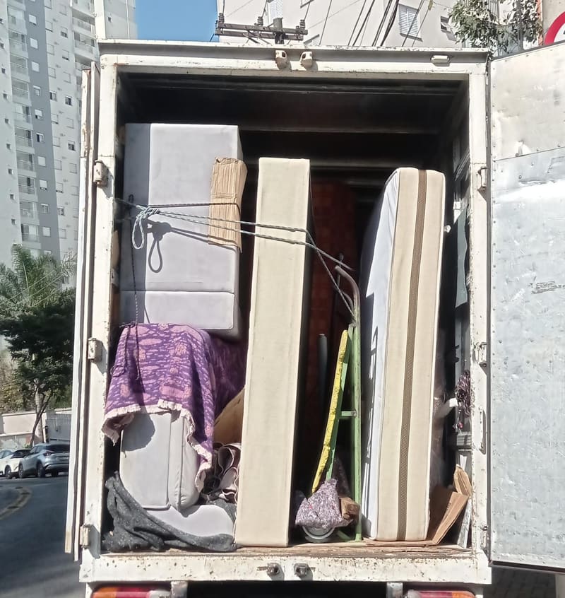 Sofá, colchões e escada amarrados dentro do caminhão para um carreto em São Paulo